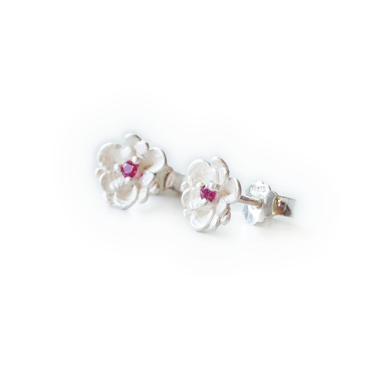 Handcrafted floral stud earrings in recycled 925 sterling silver, featuring a pink sapphire or ethical synthetic pink ruby, three-prong setting, botanical design